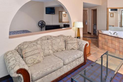 a living room with a couch and a kitchen at Economy Inn Ardmore in Ardmore