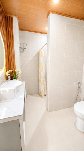 a bathroom with a toilet and a sink and a shower at Villa Lourdes in Alaminos