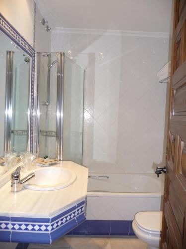 a bathroom with a sink and a tub and a toilet at Hotel Casas del sevillano in El Tornadizo