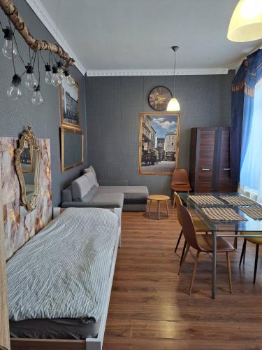 a living room with a bed and a table at Apartament M J w Centrum-Dwa Pokoje in Ząbkowice Śląskie