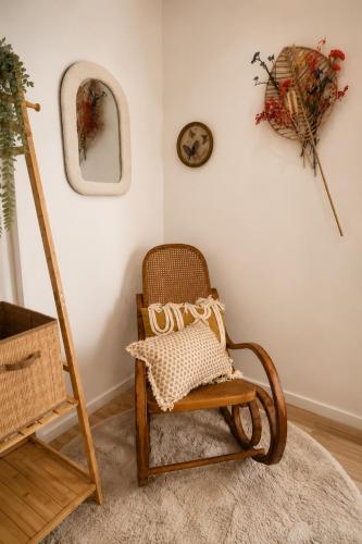 a rocking chair in a room with a clock on the wall at Le Nid des Wallabys in Monchy-le-Preux