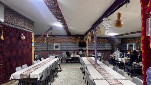 a restaurant with tables and people sitting at tables at Besqala Yurt Camp in Kabanbay
