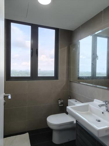 a bathroom with a toilet and a sink and two windows at Teega Suite - 5 mins from Legoland in Nusajaya