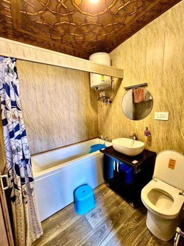 a bathroom with a toilet and a sink and a tub at Floating Luxury Group Of Houseboats in Srinagar