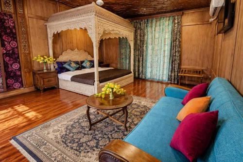a living room with a bed and a blue couch at Floating Luxury Group Of Houseboats in Srinagar
