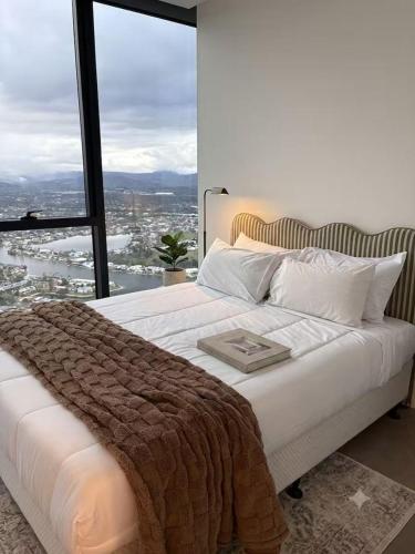 a bedroom with a large bed with a large window at OMI Collection Broadbeach in Gold Coast