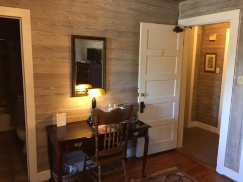 a room with a desk with a mirror and a door at 1896 O'Malley House in New Orleans