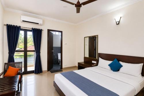 a bedroom with a king sized bed and a balcony at Sunlight Stay at Goa in Calangute