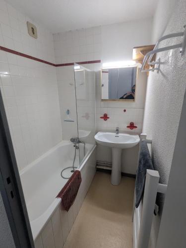 a bathroom with a sink and a tub and a toilet at Appartement au centre de Barèges in Barèges