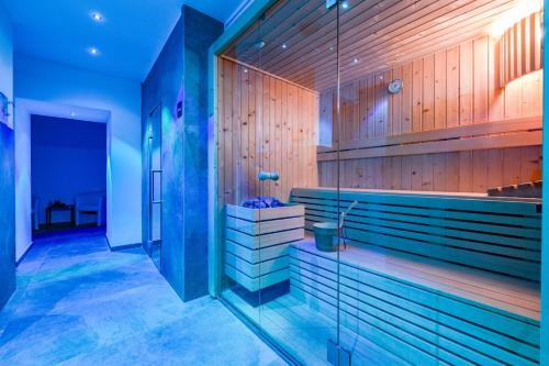 a bathroom with wooden walls and a glass wall at Park Hotel Val Di Monte ***S in Malcesine