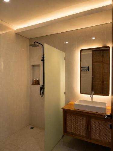 a bathroom with a sink and a mirror at Braban Sari Guest House Seminyak in Seminyak