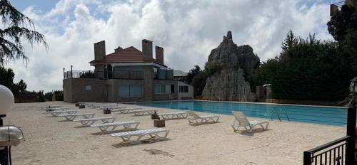 a pool with a bunch of chairs next to a building at Lesnasr chalet apartments in Al ‘Aqabah