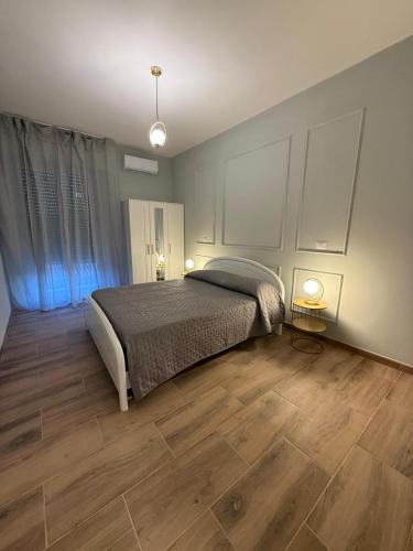 a bedroom with a bed and a wooden floor at Placanica Apartment in Calitri