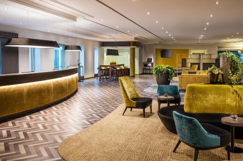 a lobby of a hotel with chairs and tables at Sheraton Duesseldorf Airport Hotel in Düsseldorf