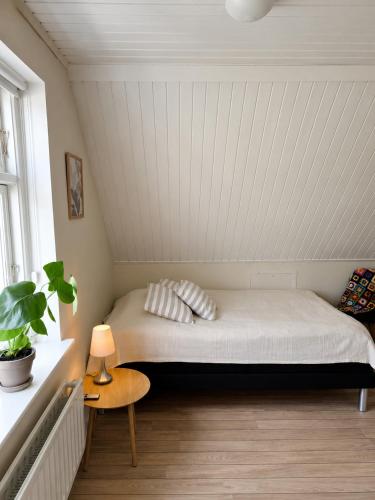 a bedroom with a bed and a table and a window at Nybo House in Præstø