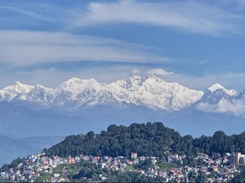 a city with mountains in the background with a city at Sri Vrindavan Guest House Pure Veg in Darjeeling