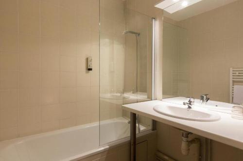 a bathroom with a sink and a shower and a tub at Appartement T3 Golf Albret in Barbaste