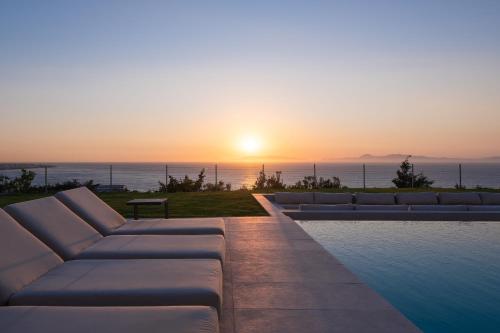 a pool with a view of the ocean at sunset at Monte Smith Luxury Villas in Rhodes Town