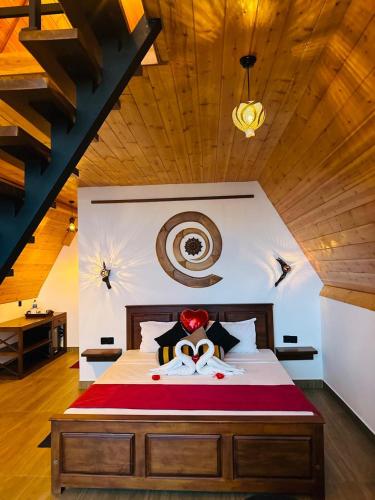 a bedroom with a large bed with a wooden ceiling at Eagle View villa in Ella