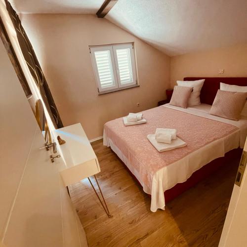 a bedroom with a bed with two towels on it at Bela & Mare in Blace