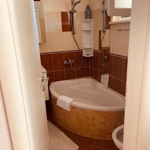 a bathroom with a tub and a toilet at Bela & Mare in Blace