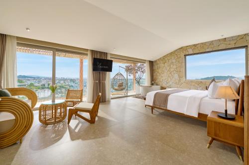 a bedroom with a large bed and large windows at Olive Hotel Da Lat in Da Lat