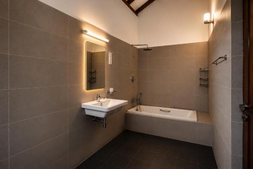 a bathroom with a sink and a bath tub at Surf Bay Villa Weligama in Pelena