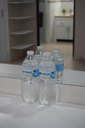 a group of four bottles of water sitting on a counter at Casa Del Pueblo in Teotitlán del Valle