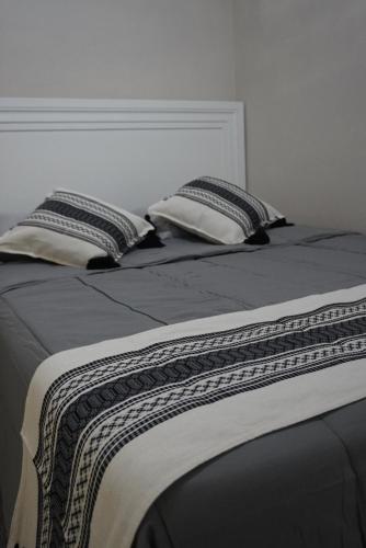 a bed with two pillows on top of it at Casa Del Pueblo in Teotitlán del Valle