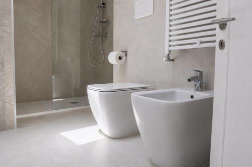 a white bathroom with a toilet and a shower at Casa Bottega in San Salvo