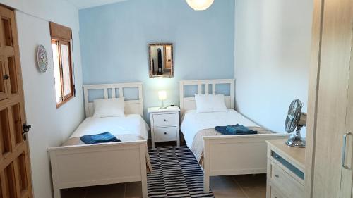 two beds in a room with blue walls at Casita Zagra in La Carrera de la Viña
