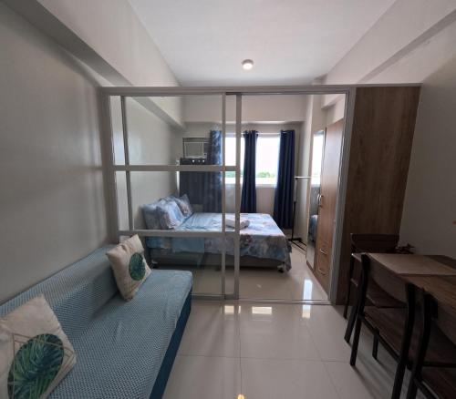 a bedroom with a bed and a couch in a room at Cozy 1BR Prime World District, Near Airport, Gaisano Grand Mall, Mactan Doctor's Hospital in Agus