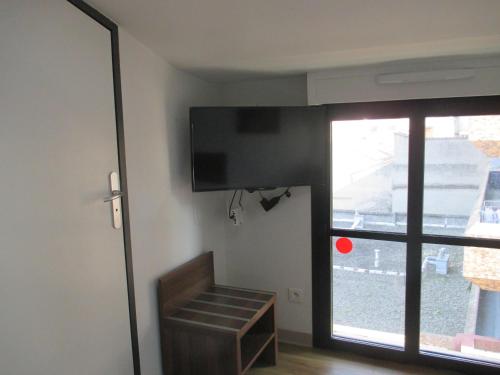 a room with a flat screen tv on the wall at Hôtel le Pastel in Toulouse