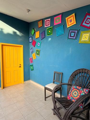 a room with a blue wall with a chair and a door at Magic Colombia in El Porvenir