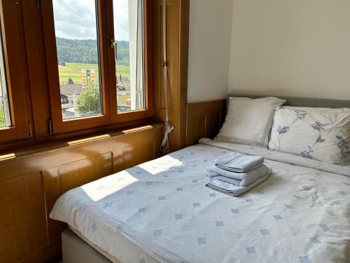 a bed with towels on it in a room with a window at Studio in Tramelan