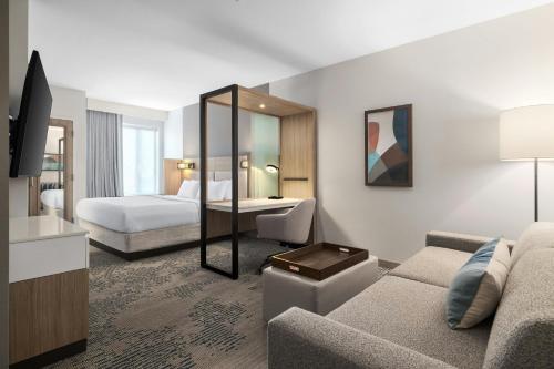 a hotel room with a couch and a bed at SpringHill Suites by Marriott Dayton Vandalia in Murlin Heights