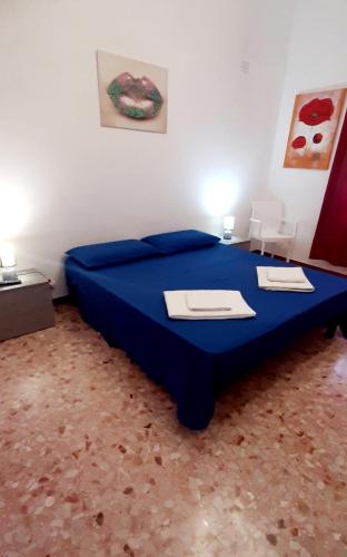 a bedroom with a blue bed with two desks on it at The house of the islands Sea view in Marausa