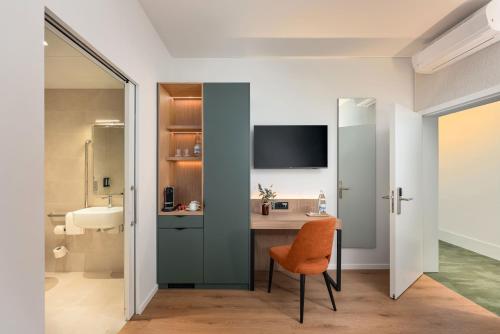 a bathroom with a desk and a chair in a room at Tailormade Hotel AL GIARDINETTO Biasca in Biasca