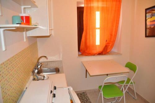 a kitchen with an orange curtain and a table and a sink at La casa del custode in Caccamo