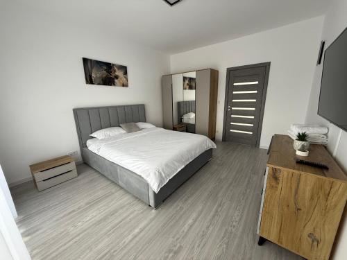 a bedroom with a bed and a dresser and a television at Malvina Apartments Cazare Mures in Târgu-Mureş