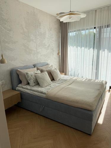 a large bed in a bedroom with a large window at Apartament Lake Mood Iława in Iława
