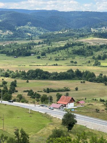 a road in the middle of a field with a house at Panorama Residence Ivan in Pljevlja