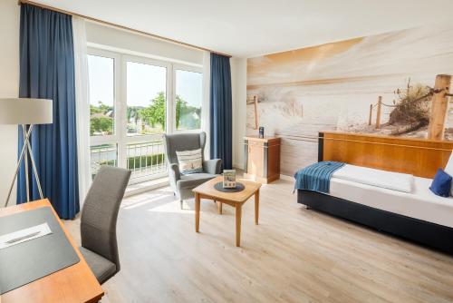 a hotel room with a bed and a desk and chair at Hotel Novum in Hinte
