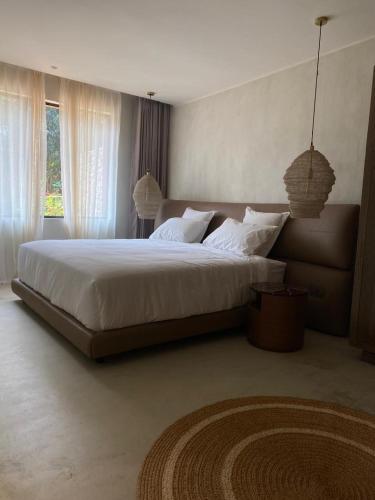 a bedroom with a large bed with white sheets and pillows at Ubucuti Gorilla Lodge in Kinigi