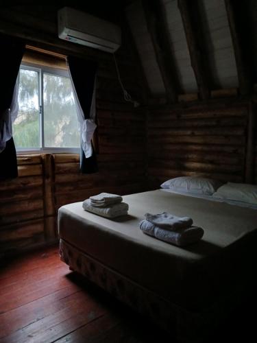 a bedroom with a bed with two towels on it at Complejo del Canton Valais in Baradero