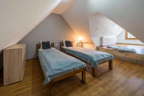 a attic room with two beds and a staircase at Pod Reglami in Krościenko