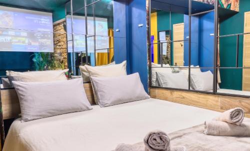 a bedroom with a large bed with white pillows at JADE Hammam & Jacuzzi in Brie-Comte-Robert