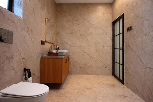 a bathroom with a toilet and a sink at Barefoot bliss by iLiF Hotels in Revadanda