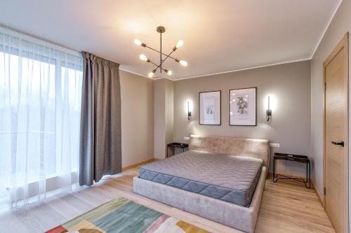 a bedroom with a bed and a large window at Imanta Garden Townhouses in Riga