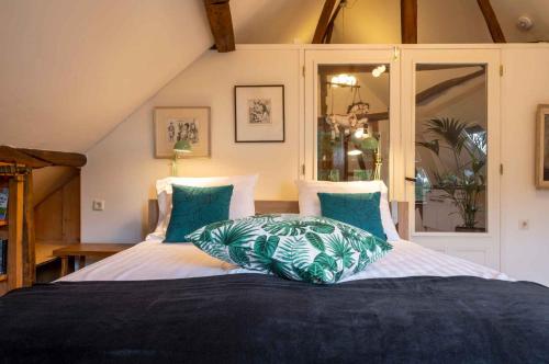 a bedroom with two beds with blue pillows at Op de Klever in Schimmert